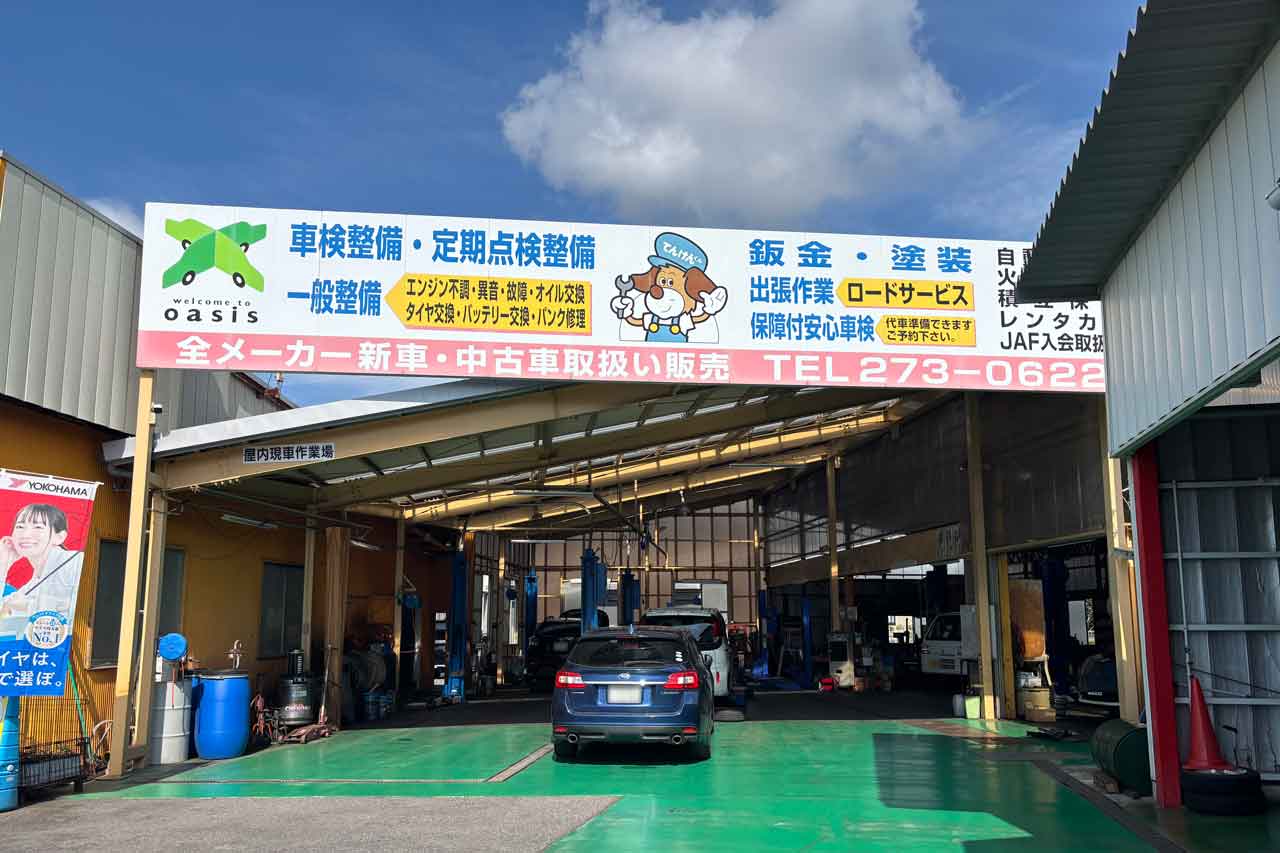 複数の車が駐車されている、屋根付きの広々とした車検・整備用ピット（作業場）の外観